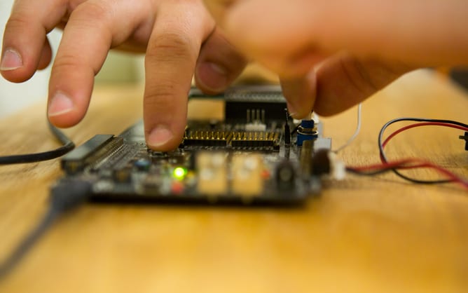 A person touches and works with a circuit