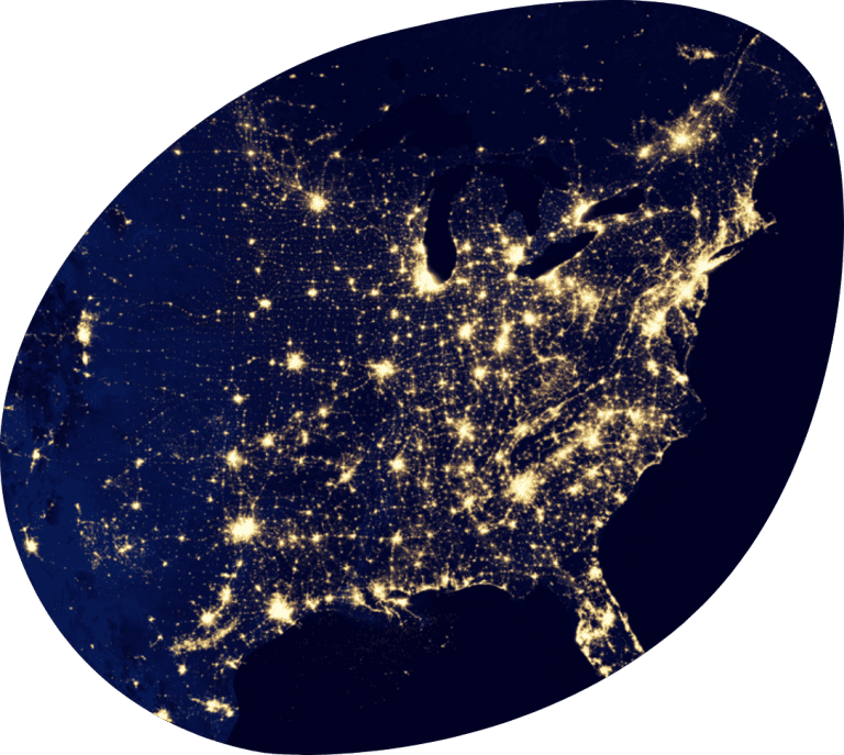 An aerial photo of the eastern half of the United States at night. The lights from large cities are very apparent.
