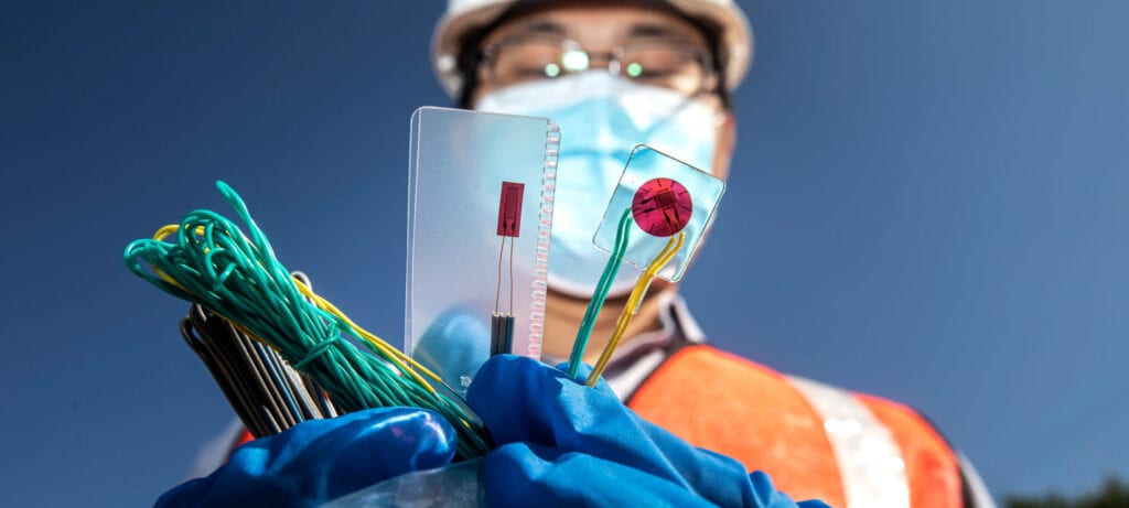 Worker holds sensor technology and wires